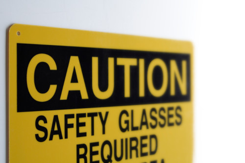 A yellow caution sign warns of the need for safety glasses.